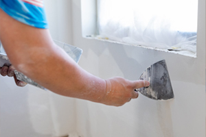 worker finishing off drywall install